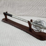 Pernach with openwork flanges, patterned shaft and black grip on a wooden display stand