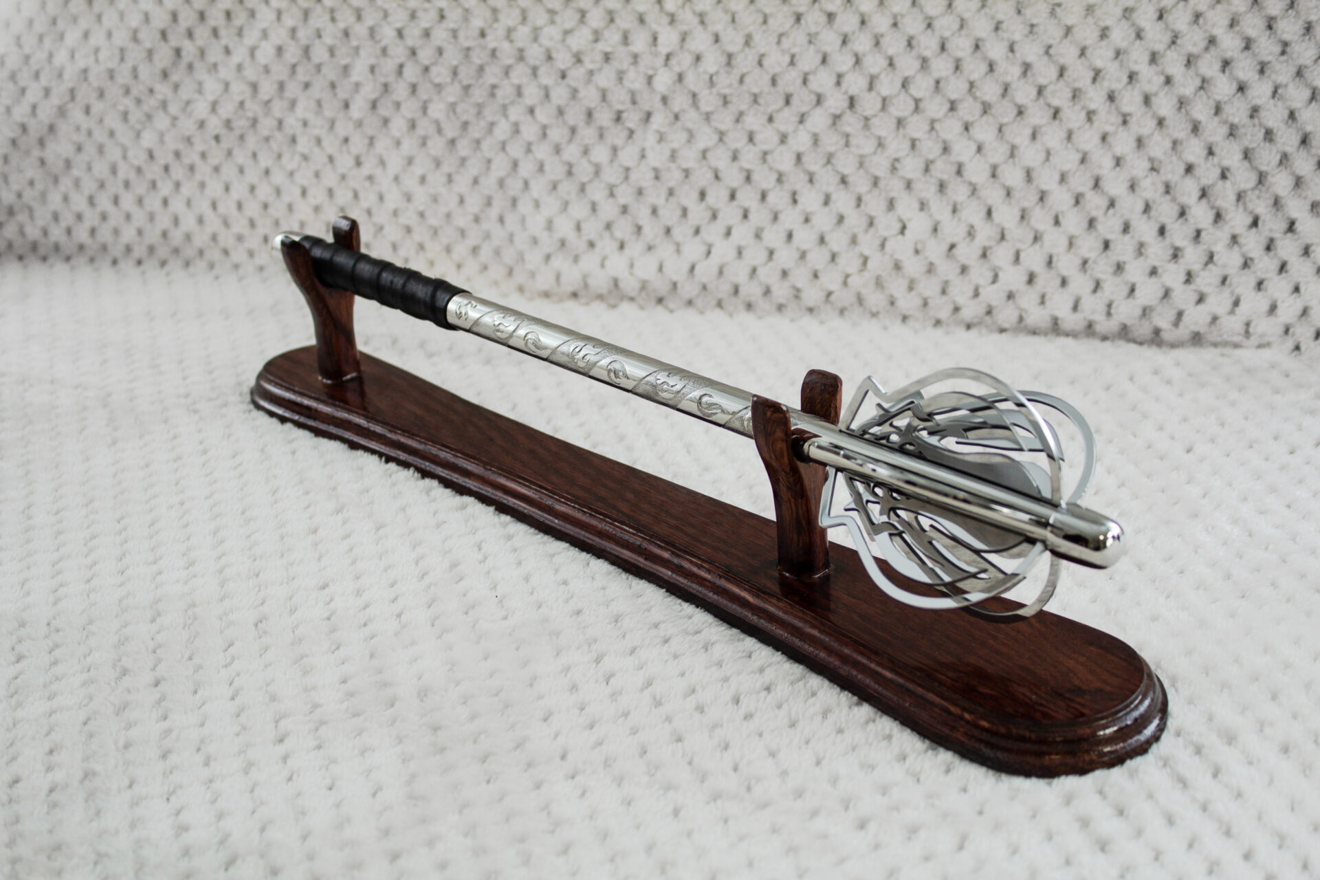 Pernach with openwork flanges, patterned shaft and black grip on a wooden display stand