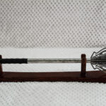 Full side profile of a pernach on a wooden stand, with openwork flanges and black wrapped grip