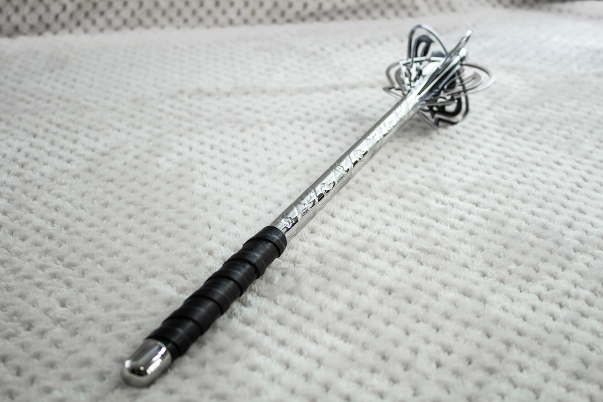 Pernach viewed along its patterned shaft from the black grip toward the openwork head