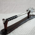 Pernach on a wooden stand viewed from the black wrapped grip along its smooth shaft