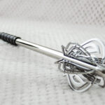 Pernach with openwork flanges and a smooth reflective shaft, viewed from the head toward the black grip
