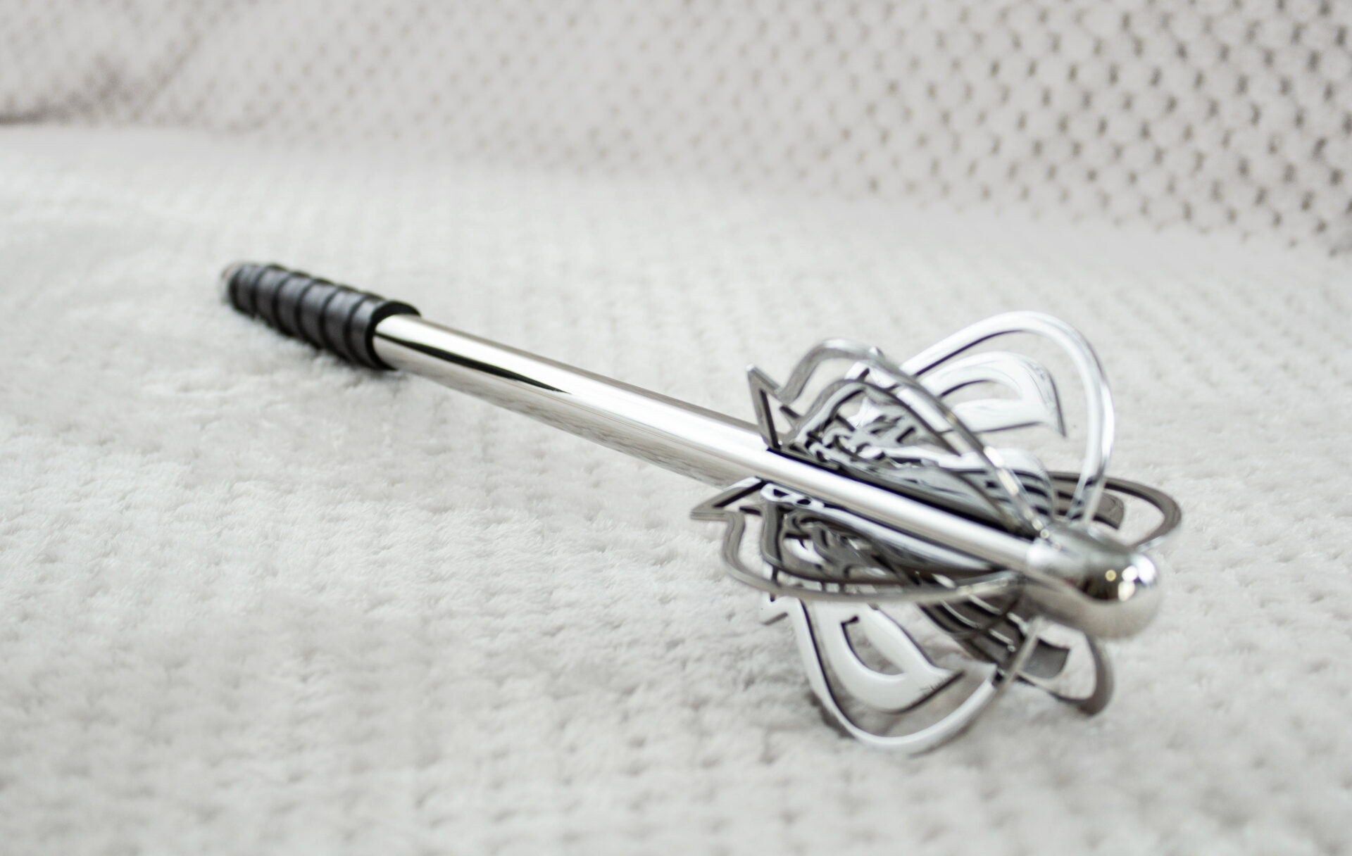 Pernach with openwork flanges and a smooth reflective shaft, viewed from the head toward the black grip