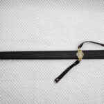 Sviatoslav's sword sheathed in black, with geometric patterns on the tip, carrying-strap fitting and hilt