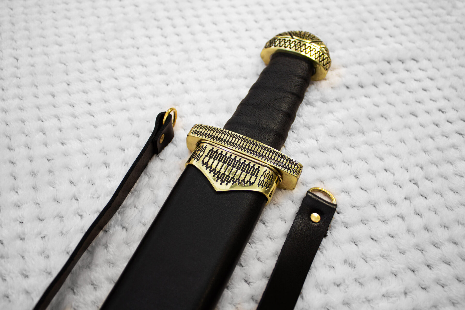Close-up of Sviatoslav's sword in its scabbard, showing the black grip, patterned guard and pommel