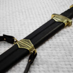 Back of the black scabbard for Sviatoslav's sword, showing its central stitched seam, patterned fittings and strap
