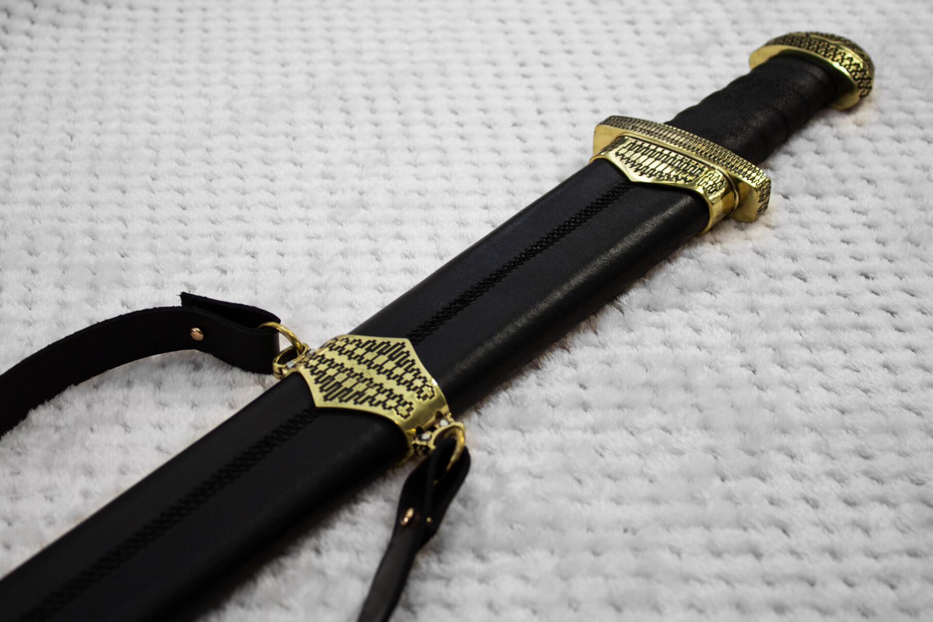 Back of the black scabbard for Sviatoslav's sword, showing its central stitched seam, patterned fittings and strap