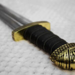 Close-up of the black wrapped grip, patterned pommel and guard of Sviatoslav's sword