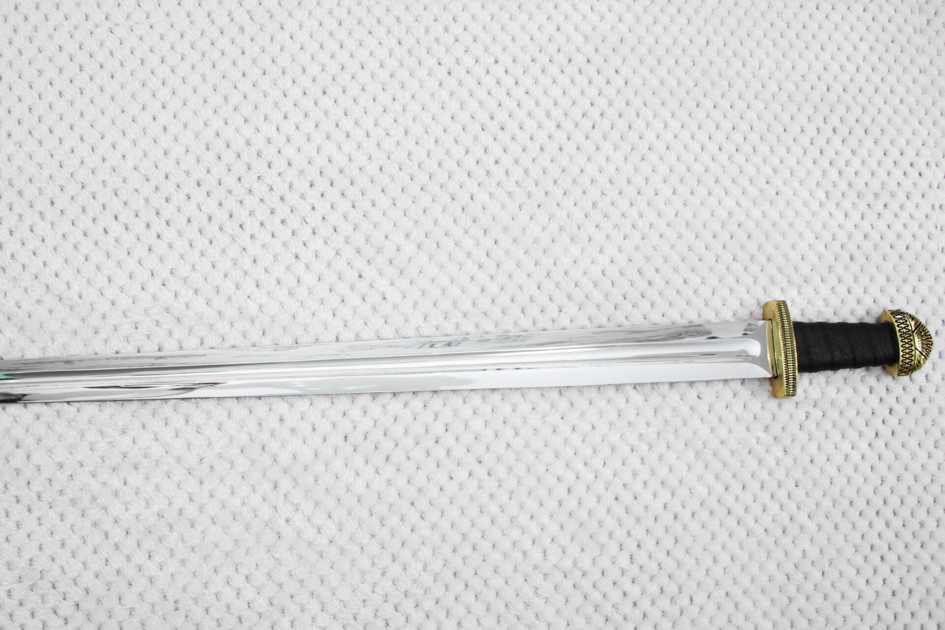 Unsheathed Sviatoslav's sword with a straight fullered blade, short guard and black wrapped grip