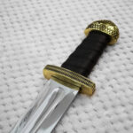Detailed view of Sviatoslav's sword grip between the geometric-patterned guard and domed pommel