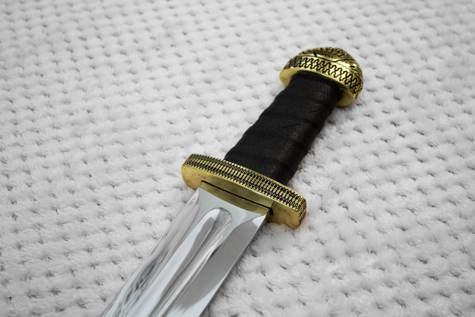 Detailed view of Sviatoslav's sword grip between the geometric-patterned guard and domed pommel