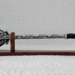 Side profile of a pernach with dark patterns on its flanges and shaft, displayed on a wooden stand