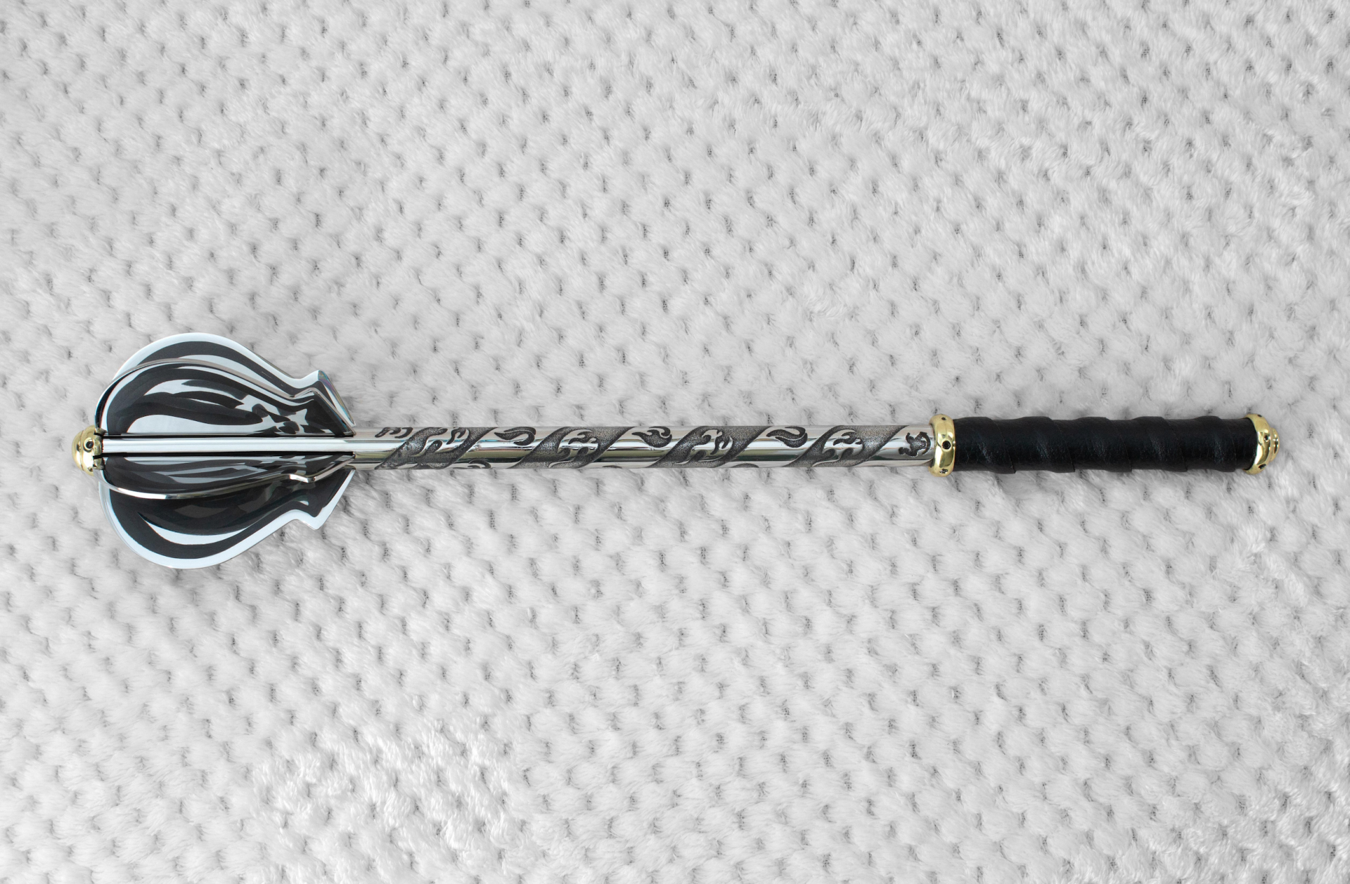 Pernach without its stand, shown from above with dark patterned flanges, ornamental shaft and black grip