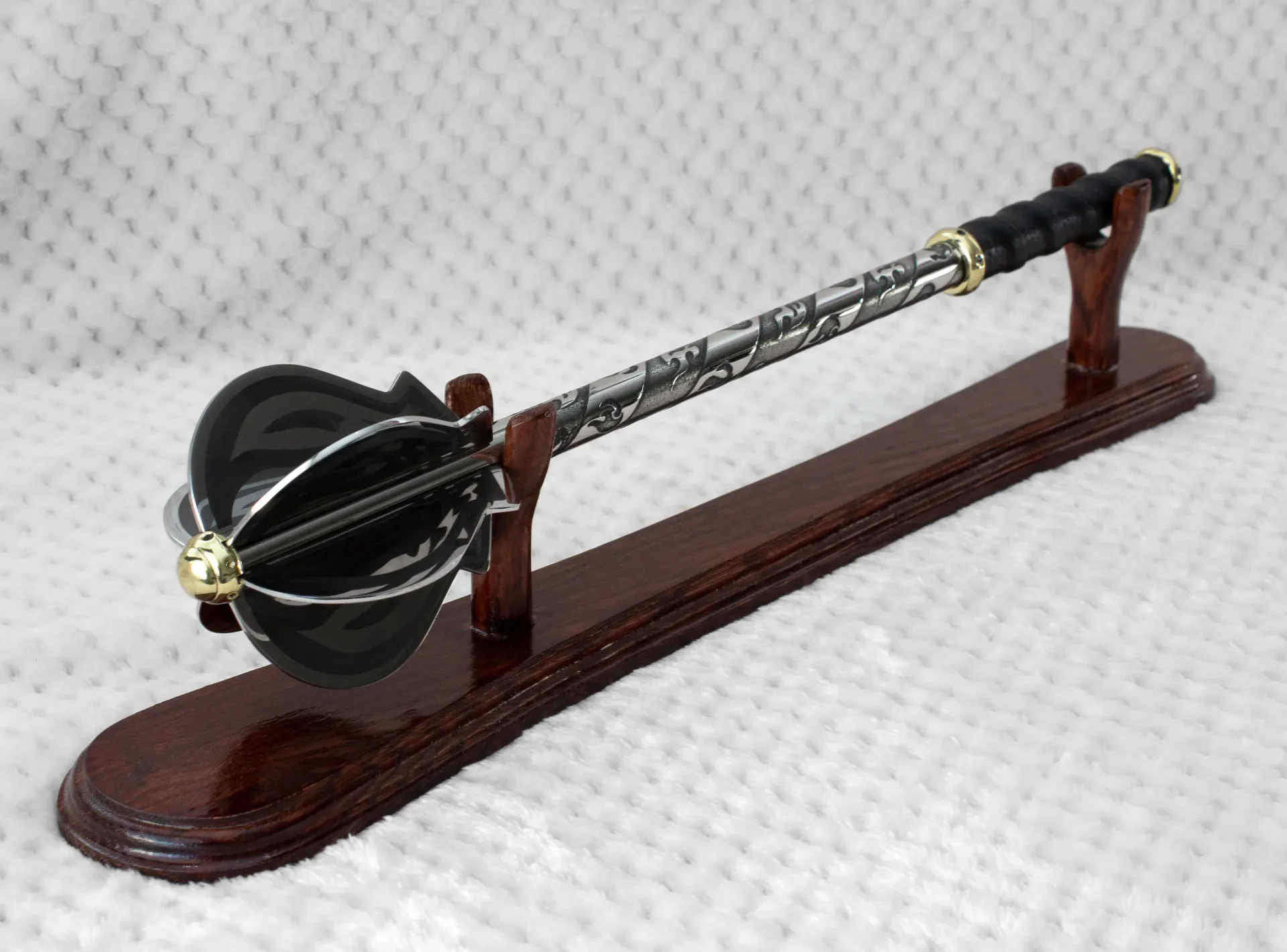 Pernach on a wooden display stand, showing its flanged head, patterned shaft and black grip