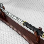 Pernach on a wooden stand viewed from the black grip along its patterned shaft toward the flanged head