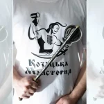Pernach held diagonally in front of a white Cossack Workshop logo shirt
