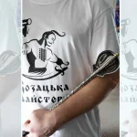 Patterned pernach held along a forearm in front of a Cossack Workshop shirt