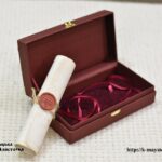 Rolled gift scroll with a wax seal beside an open presentation box lined with red fabric