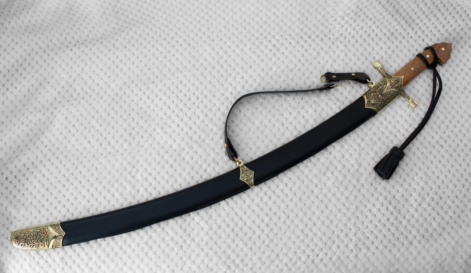 SiCh-KzO saber in a black scabbard with decorated fittings, viewed at an angle