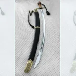 SiCh-KzO saber beside its black scabbard, with the brown grip at the top