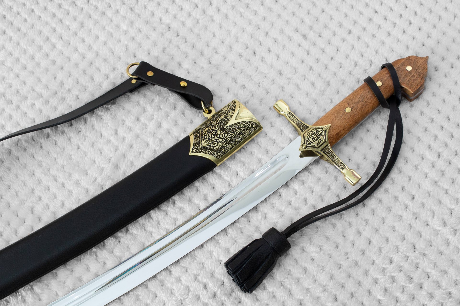 SiCh-KzO saber with brown grip and decorated guard beside its black scabbard