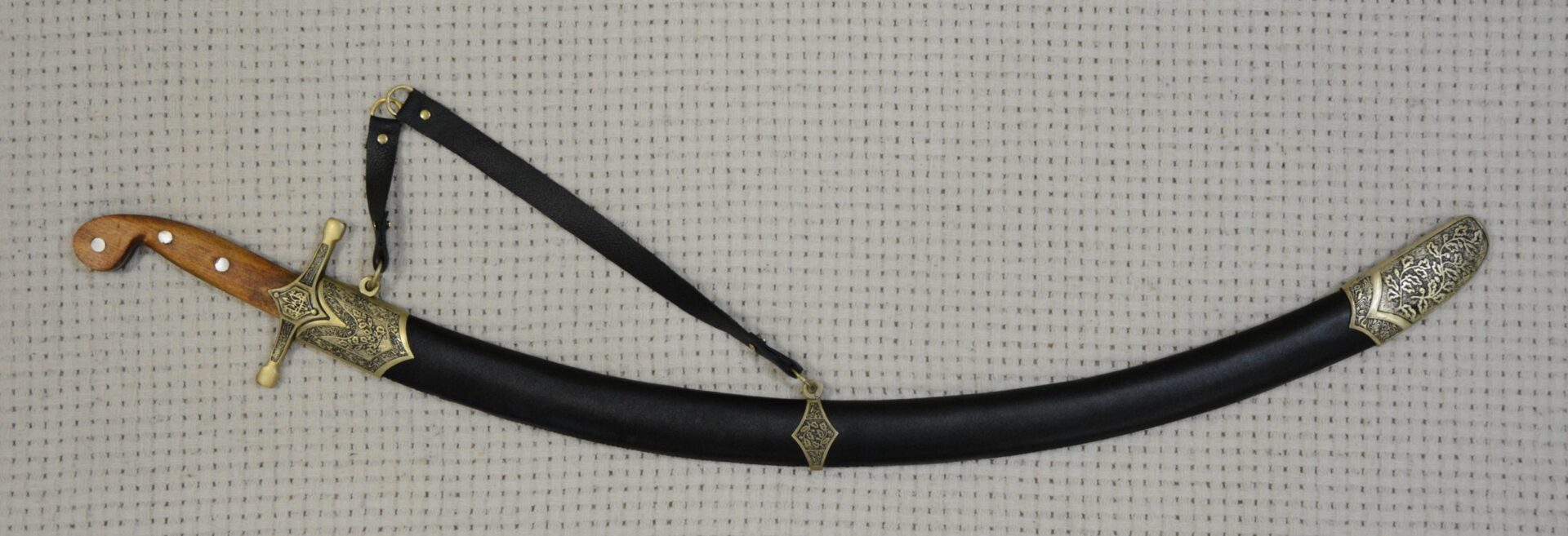 SiCh-Sh saber in a black scabbard with decorated fittings and a suspension strap, side view