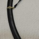 SiCh-Sh saber in its black scabbard, viewed along the suspension strap toward the brown grip