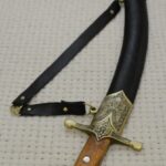 Black SiCh-Sh scabbard viewed toward its decorated tip, showing the strap attachment