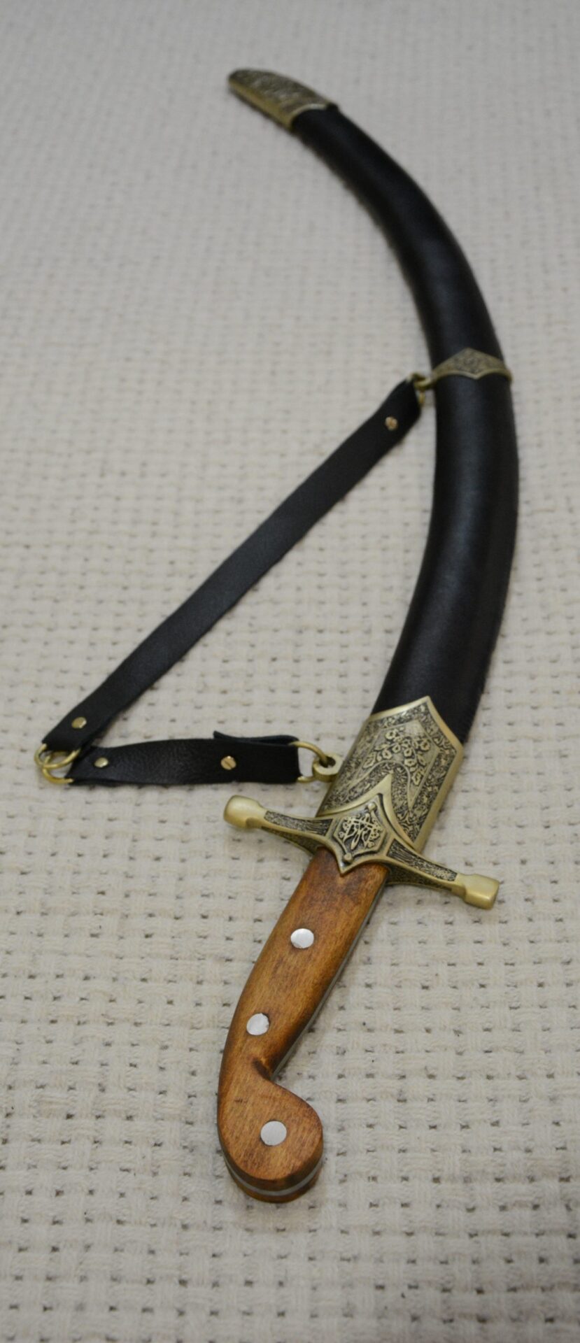 Black SiCh-Sh scabbard viewed toward its decorated tip, showing the strap attachment