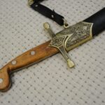 SiCh-Sh saber in its scabbard: close-up of the brown grip and decorated guard and scabbard fitting