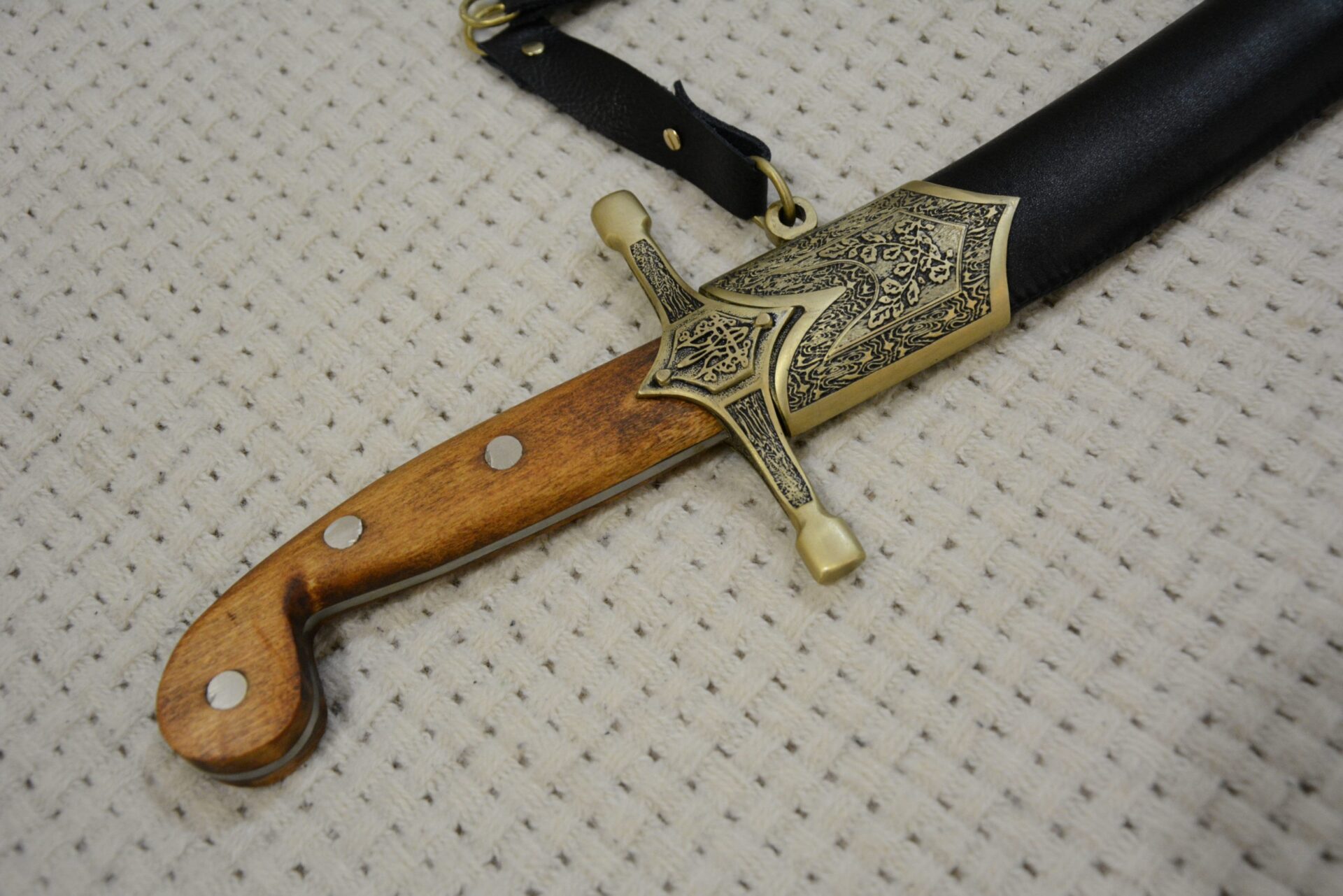 SiCh-Sh saber in its scabbard: close-up of the brown grip and decorated guard and scabbard fitting