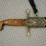 Close-up of the SiCh-Sh brown grip, decorated crossguard and scabbard throat
