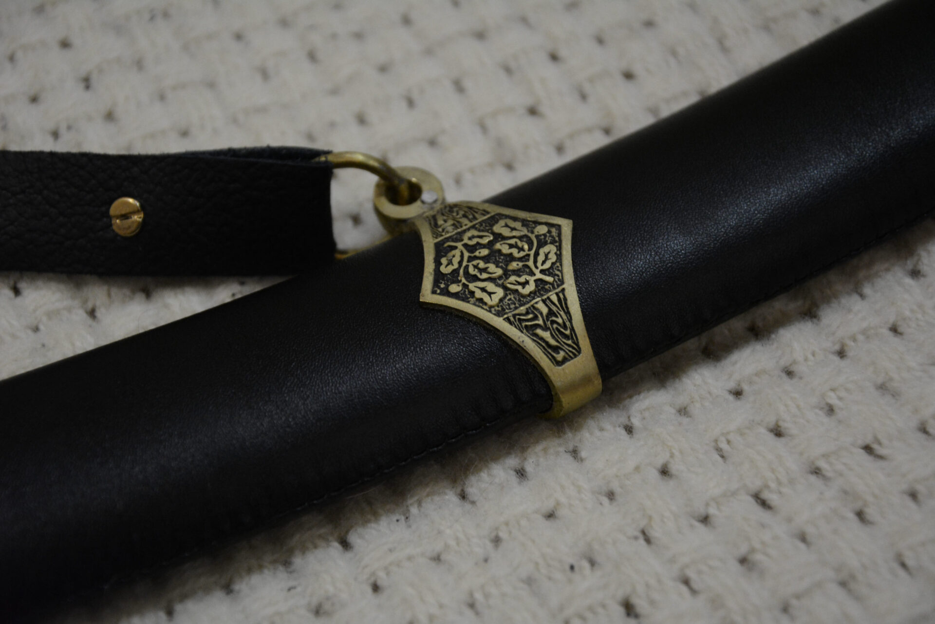 Close-up of the decorated suspension band and strap ring on the black SiCh-Sh scabbard