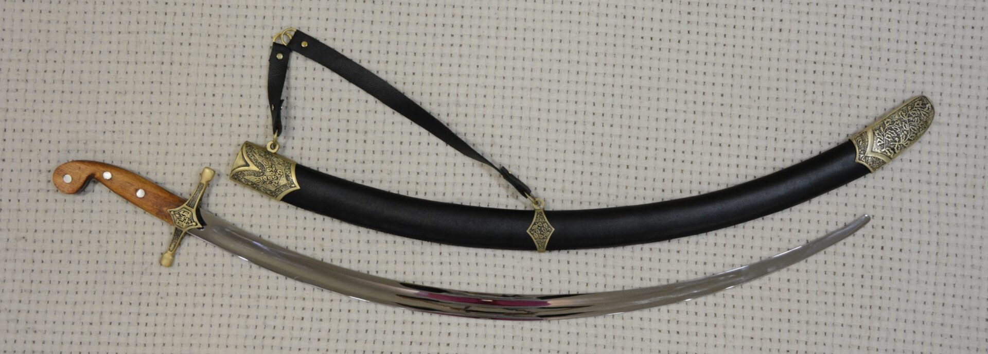 Unsheathed SiCh-Sh saber beside its black decorated scabbard, full side view