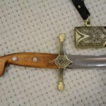 SiCh-Sh brown grip with three visible rivets and decorated crossguard beside the scabbard opening