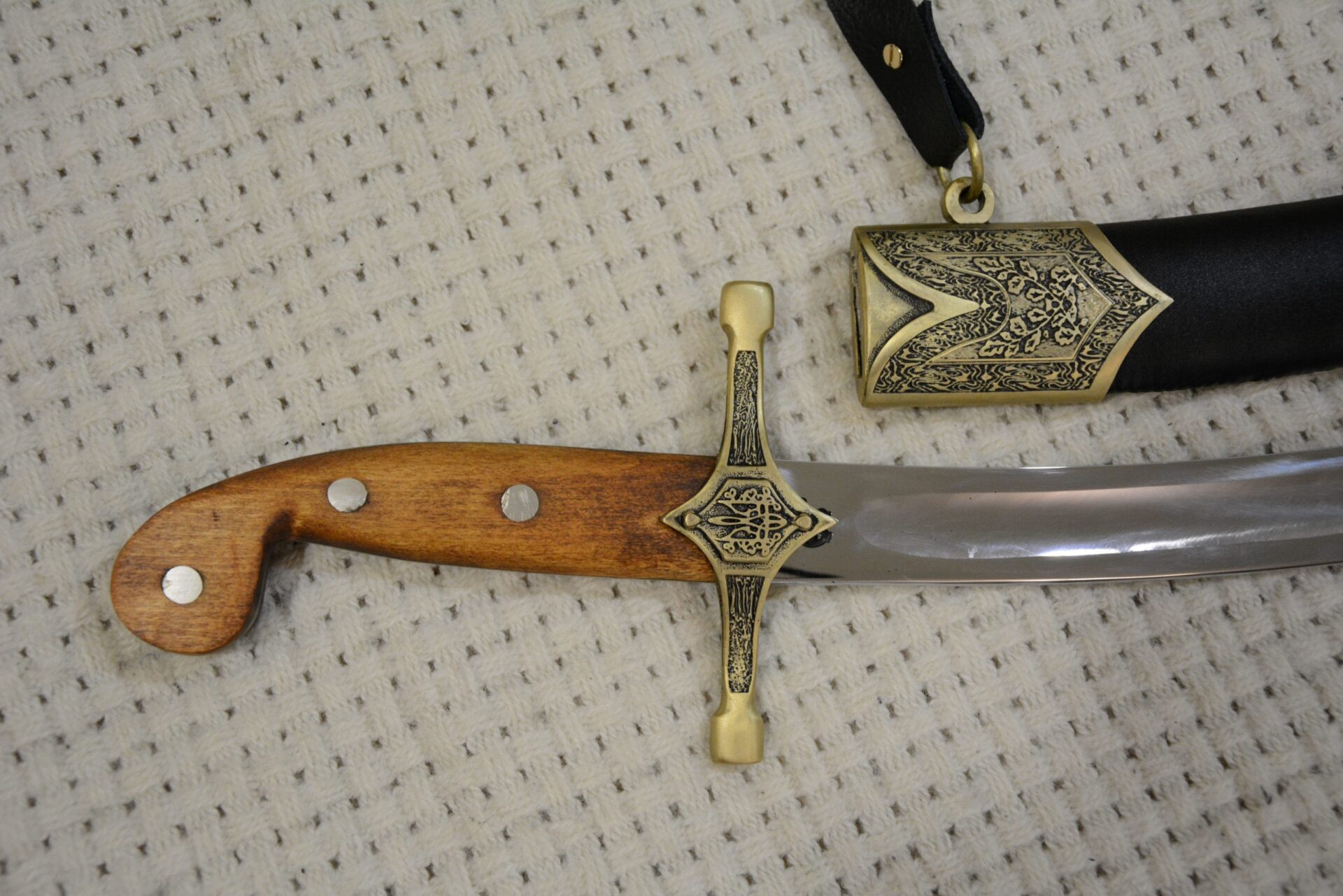 SiCh-Sh brown grip with three visible rivets and decorated crossguard beside the scabbard opening