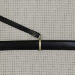 Full side view of a Cossack shashka in a black scabbard with carrying straps and a black tassel