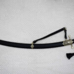 SiCh-Hetman saber in its black scabbard, shown from the side with carrying strap and patterned fittings
