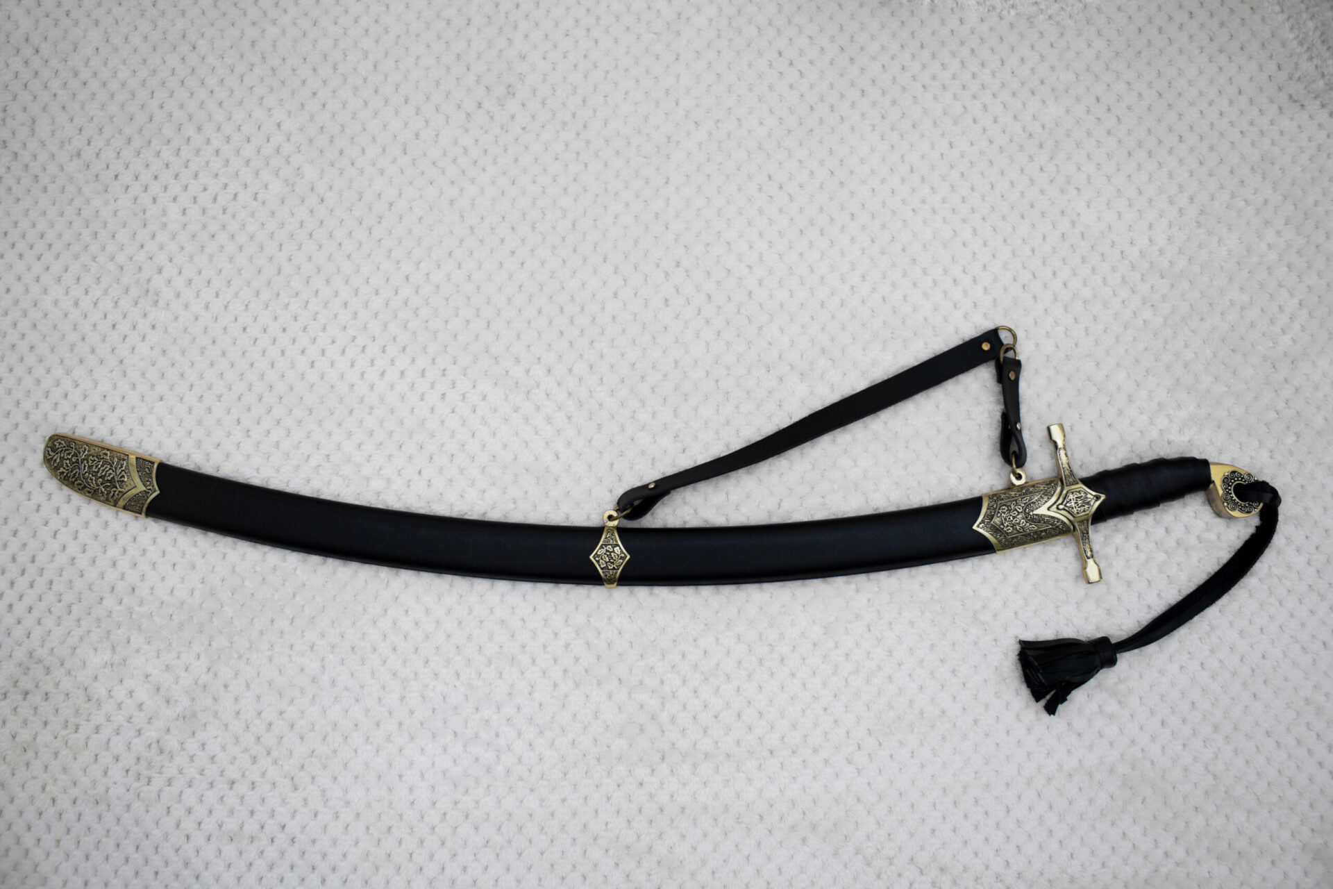 SiCh-Hetman saber in its black scabbard, shown from the side with carrying strap and patterned fittings