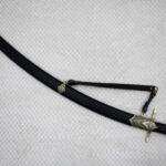 SiCh-Hetman saber in a curved black scabbard with a decorated tip and carrying strap, diagonal view