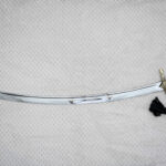 Unsheathed SiCh-Hetman saber with curved fullered blade, decorated guard, black grip and tassel