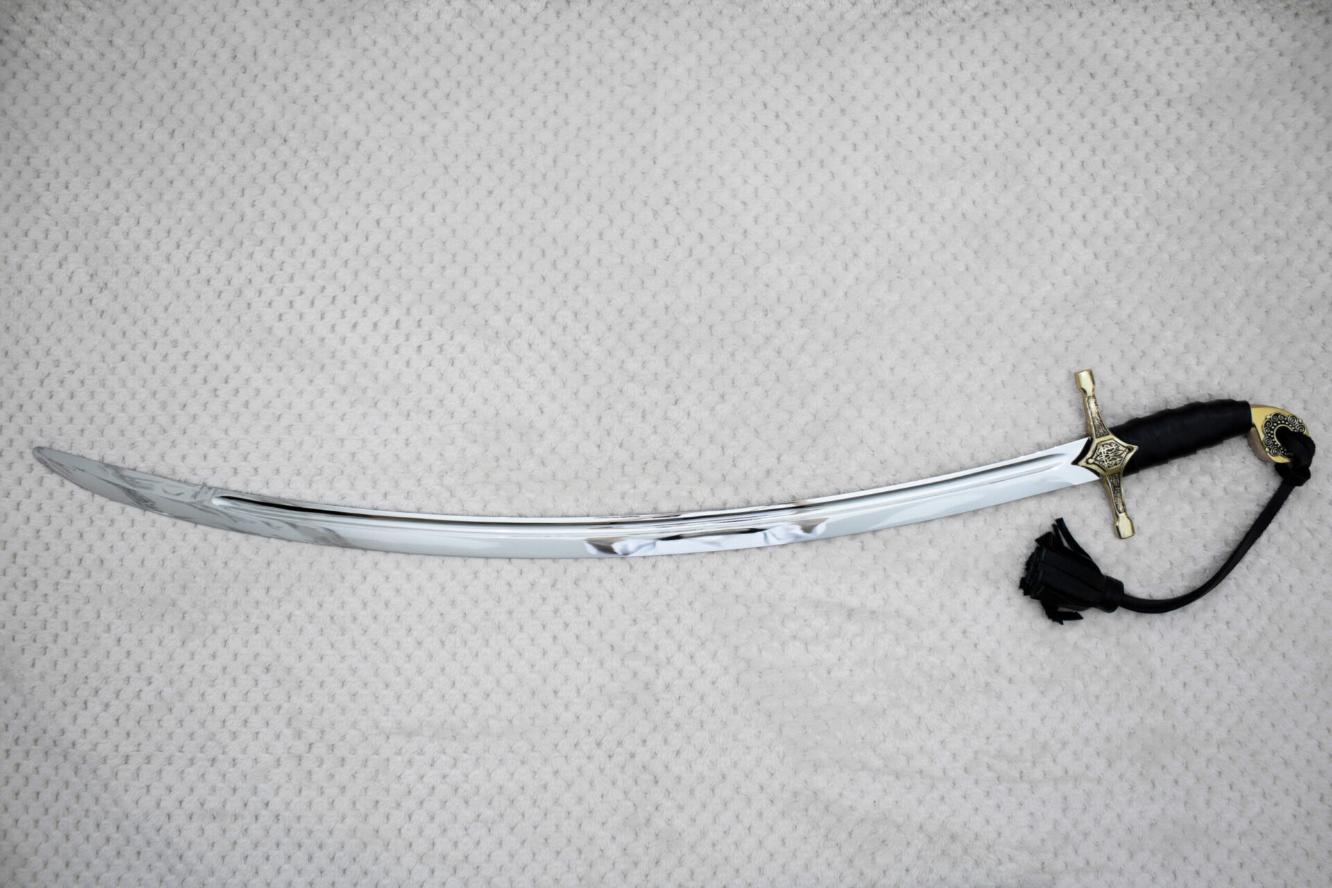 Unsheathed SiCh-Hetman saber with curved fullered blade, decorated guard, black grip and tassel