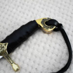 Close-up of the SiCh-Hetman saber hilt with black wrapped grip, patterned pommel and decorated guard