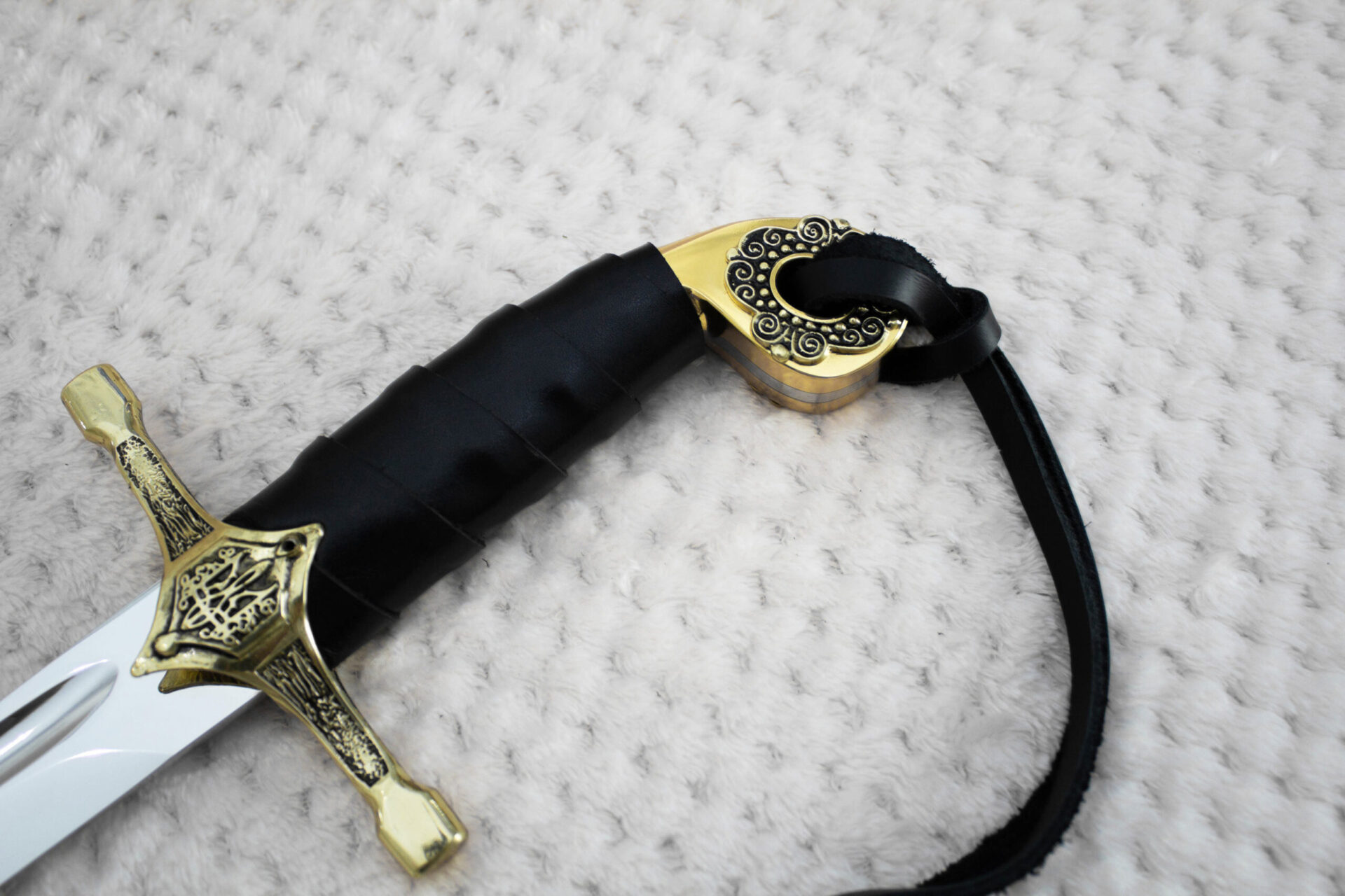 Close-up of the SiCh-Hetman saber hilt with black wrapped grip, patterned pommel and decorated guard
