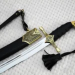 Close-up of the SiCh-Hetman saber guard, black wrapped grip and ornamental scabbard mouth