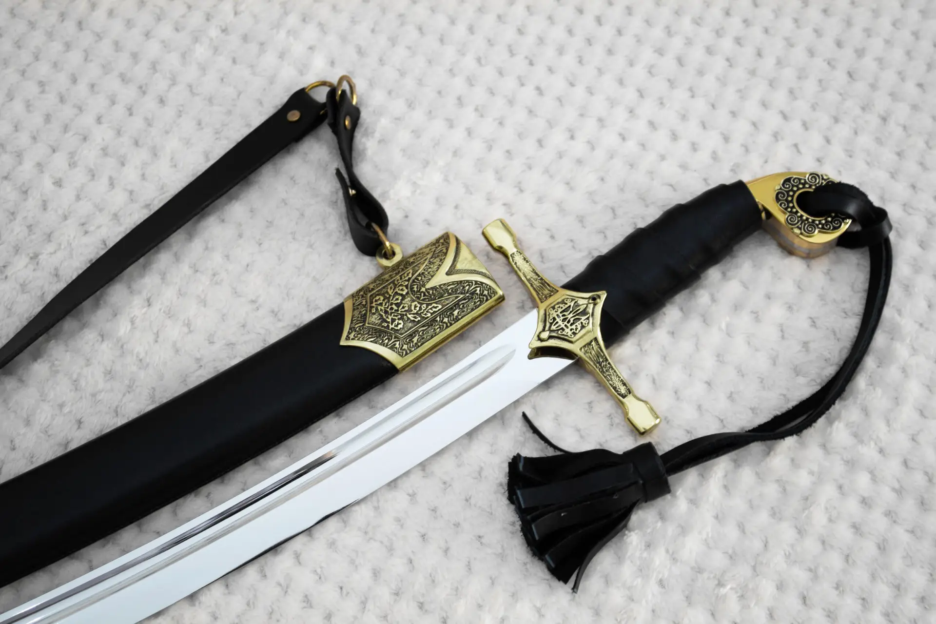 Close-up of the SiCh-Hetman saber guard, black wrapped grip and ornamental scabbard mouth