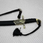 Sheathed SiCh-Hetman saber close-up with decorated guard, patterned scabbard mouth, black grip and carrying strap