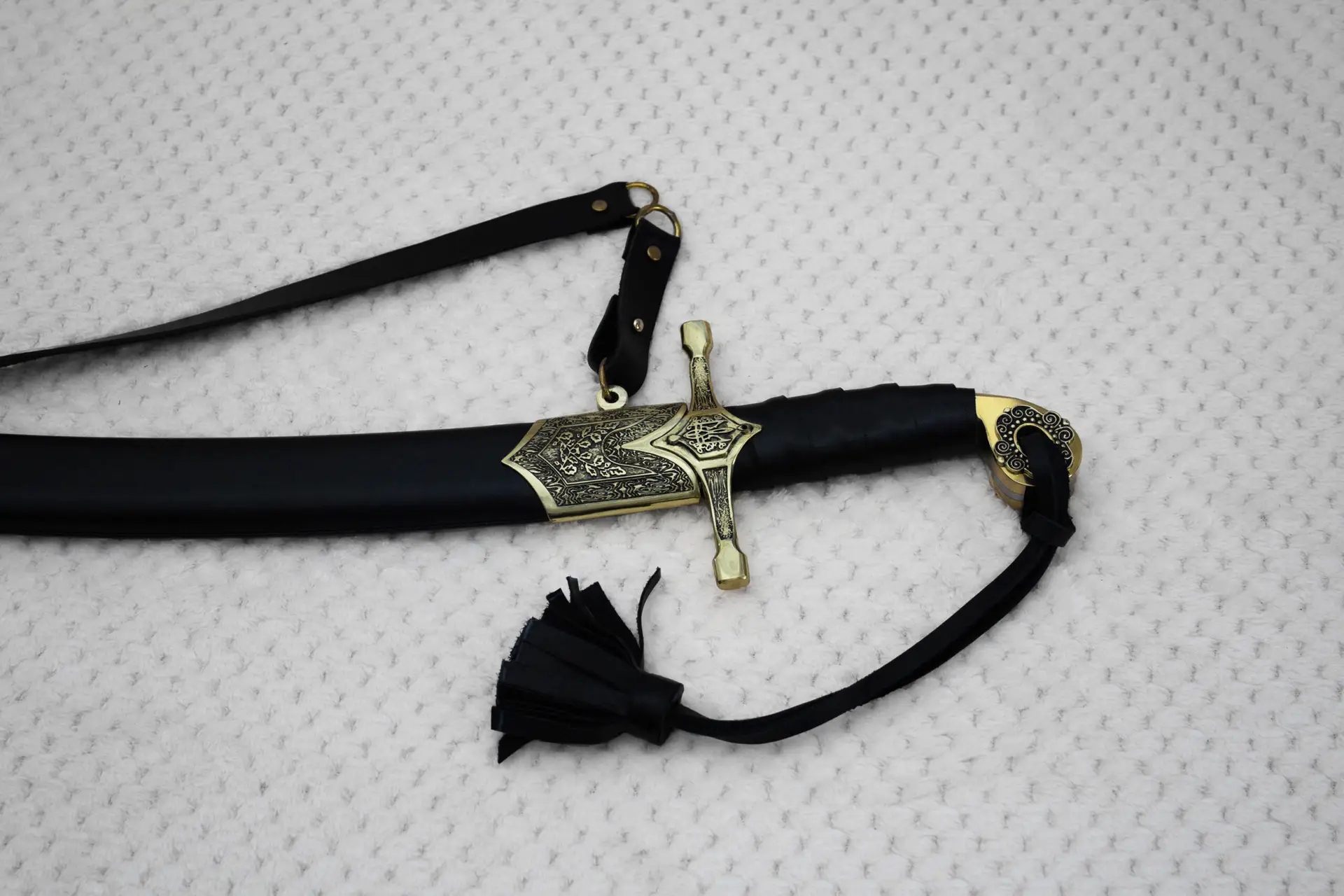 Sheathed SiCh-Hetman saber close-up with decorated guard, patterned scabbard mouth, black grip and carrying strap