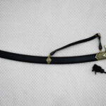 Full side view of the SiCh-Souvenir saber in its black scabbard with patterned fittings and carrying strap
