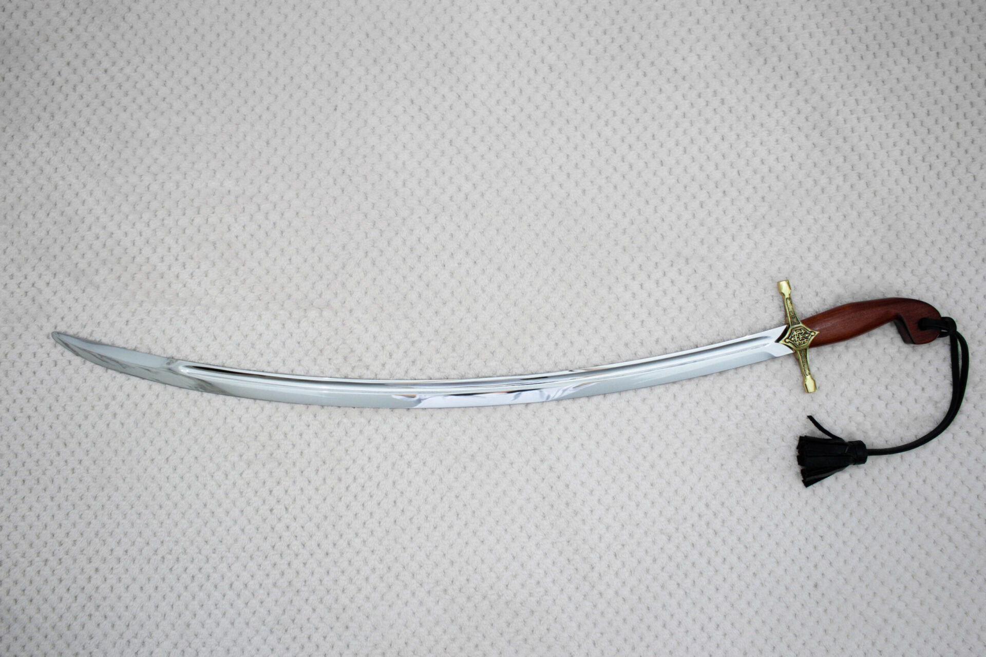 Full side view of the SiCh-Souvenir saber with curved fullered blade, decorated guard and reddish-brown grip